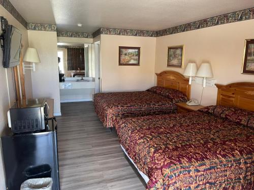 a hotel room with two beds and a television at Lakeside inn & suites by OYO Mathis I 37 in Mathis