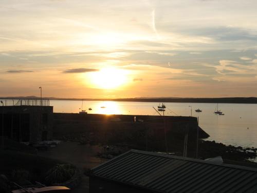 a sunset over a body of water with boats in it at Seacrest Guesthouse in Mullaghmore