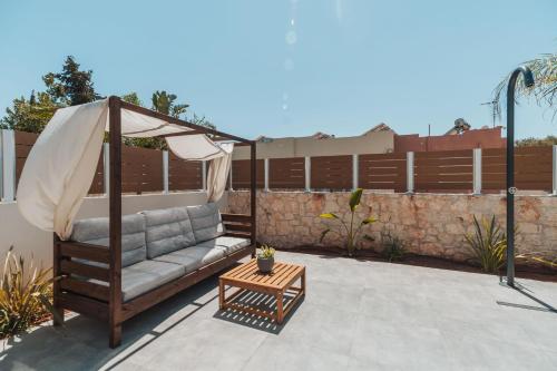 a gazebo with a couch on a patio at Nos Aqua Villas Chania in Pazinos