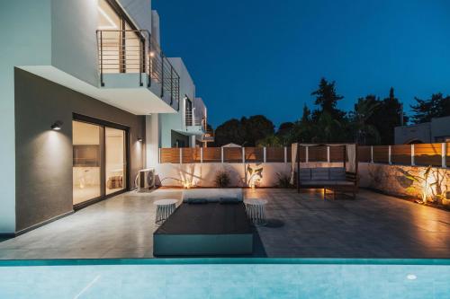 a villa with a swimming pool at night at Nos Aqua Villas Chania in Pazinos
