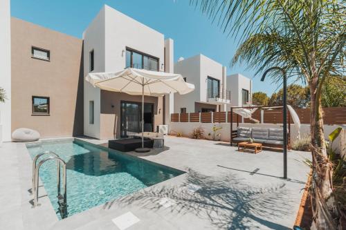 a villa with a swimming pool and a house at Nos Aqua Villas Chania in Pazinos