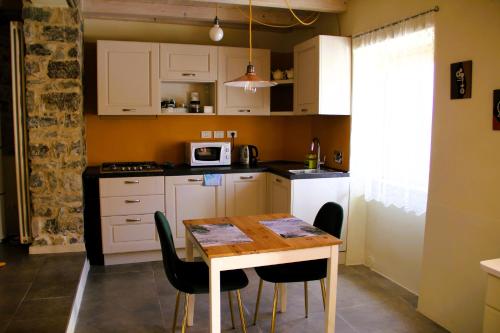 eine Küche mit Tisch und Stühlen in einem Zimmer in der Unterkunft La Casa del Sole a Cosy Nest in Lunigiana, Tuscany in Giucano