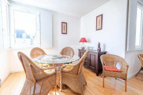 une salle à manger avec une table en verre et des chaises en osier dans l'établissement La Monnaie du Vieux Tours, à Tours