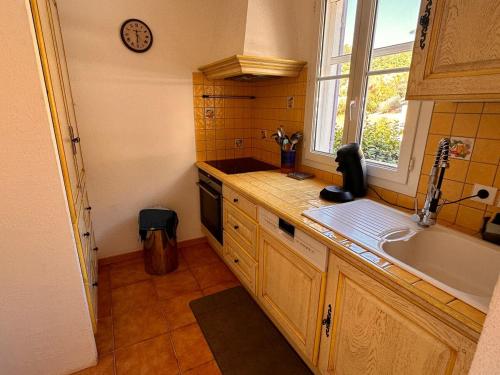une petite cuisine avec un évier et une fenêtre dans l'établissement Appt 87m2 - 3 étoiles - parking - wifi - clim - piscine, à Roquebrune-sur Argens