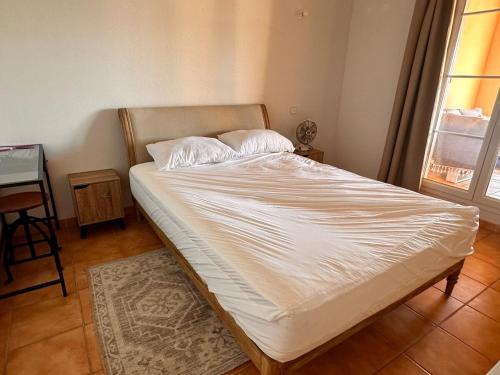 un grand lit dans une chambre avec une fenêtre dans l'établissement Appt 87m2 - 3 étoiles - parking - wifi - clim - piscine, à Roquebrune-sur Argens