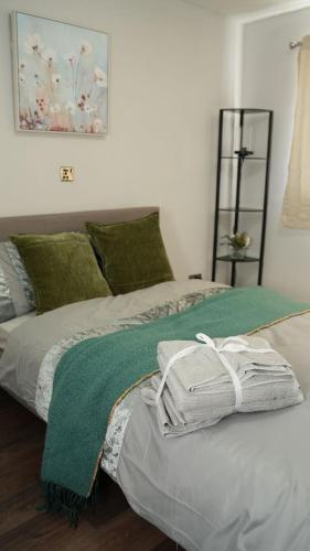 a bed with a green blanket on top of it at ODAFRO Properties in Kent