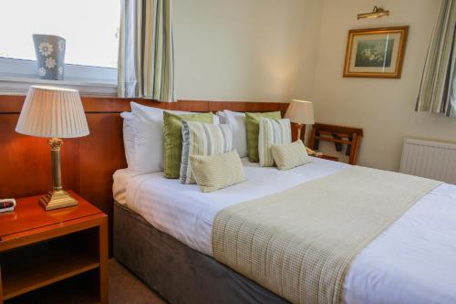 a bedroom with a bed and a table with a lamp at Highgrove House Hotel in Loans