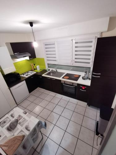 une petite cuisine avec un évier et une cuisinière dans l'établissement Apartment Proche de la gare, à Lorient