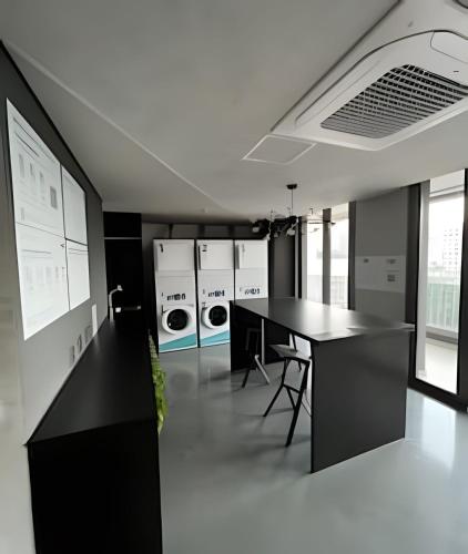 a kitchen with a black table and washing machines at Apartamentos em frente ao Allianz Parque in Sao Paulo