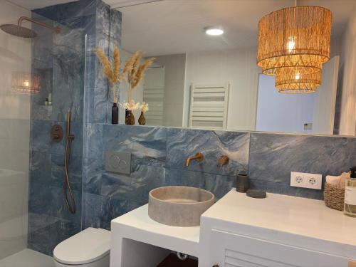 a bathroom with a sink and a toilet and a mirror at El Mirador de NaLi - accès direct à la plage in Arenal d'en Castell