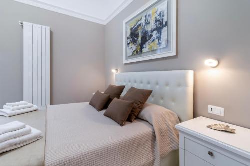 a bedroom with a bed with a white headboard at Heart City Rooms in Catania