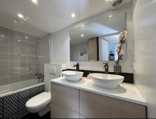 une salle de bain avec deux lavabos et un WC et un miroir dans l'établissement Charmant appartement 3p en bord de mer terrasse parking, à Beaulieu-sur-Mer