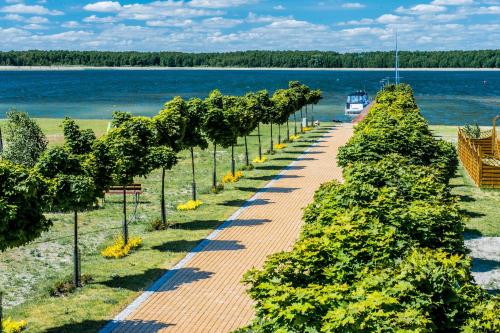 a row of trees next to a body of water at Aparthotel EuforiaPort in Pisz