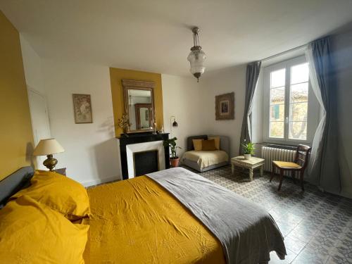 a bedroom with a yellow bed and a living room at Les volets verts in Saint-Laurent-de-la-Cabrerisse