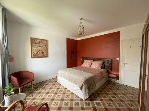 a bedroom with a bed and a red wall at Les volets verts in Saint-Laurent-de-la-Cabrerisse