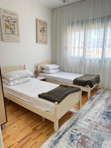 a bedroom with two beds and a window at Sol Apartments - 2 Bedrooms in Shkodër
