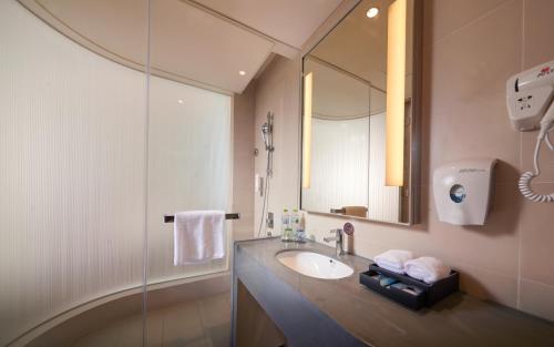 uma casa de banho com um lavatório e um espelho em Holiday Inn Express Chengdu Huanhuaxi, an IHG Hotel em Chengdu