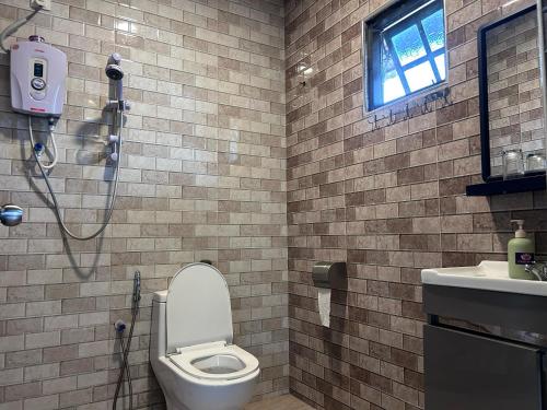 a bathroom with a shower and a toilet and a sink at Tekoma Resort Cameron Highlands in Tanah Rata