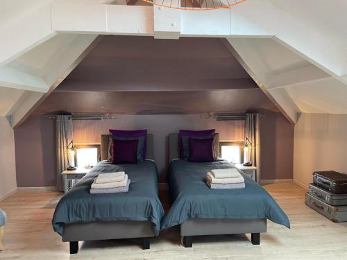 deux lits dans une chambre avec un grenier dans l'établissement Favau, à Villeneuve-sur-Lot