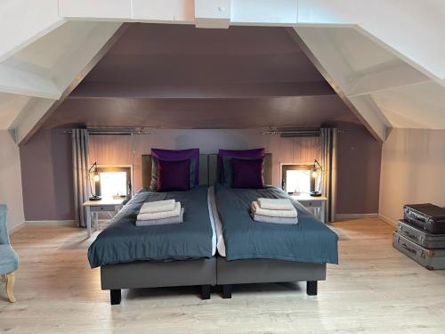 - une chambre avec un grand lit et des oreillers violets dans l'établissement Favau, à Villeneuve-sur-Lot