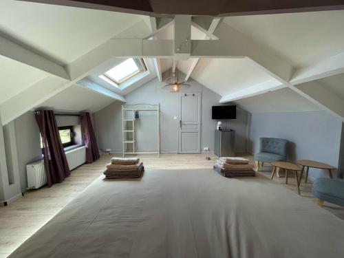 Cette chambre mansardée comprend un grand lit et une fenêtre. dans l'établissement Favau, à Villeneuve-sur-Lot