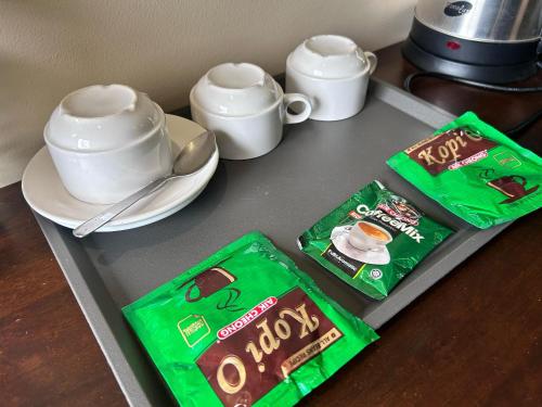 a tray with two bags of oreos and a cup of coffee at Tekoma Resort Cameron Highlands in Tanah Rata