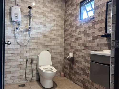 a bathroom with a shower and a toilet and a sink at Tekoma Resort Cameron Highlands in Tanah Rata