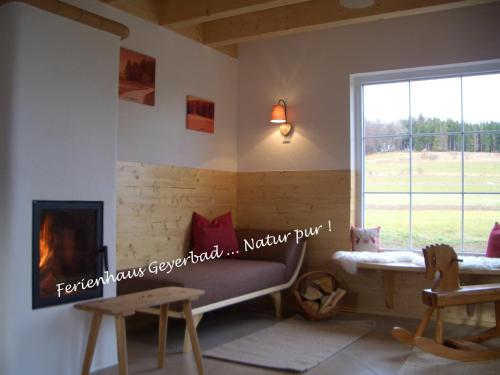 Una sala de estar con chimenea y una ventana. en Ferienhaus Geyerbad, en Meßstetten