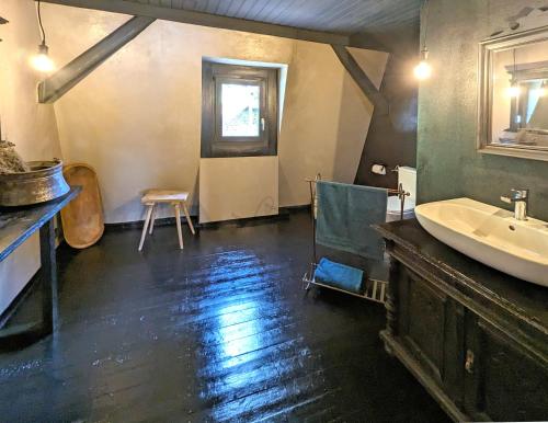 a bathroom with a sink and a tub and a chair at Zeller Kehr Wohnung in Zell an der Mosel