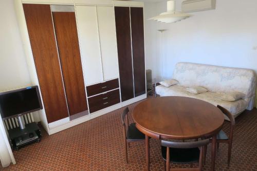 un salon avec une table et un canapé dans l'établissement T2 dans une résidence proche de la mer et du centre du village, à Porquerolles