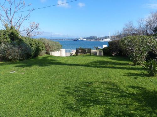un banc de parc assis dans l'herbe près de l'eau dans l'établissement T2 dans une résidence proche de la mer et du centre du village, à Porquerolles