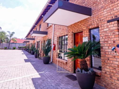 a brick building with potted plants outside of it at The Grand Comfort in Rustenburg