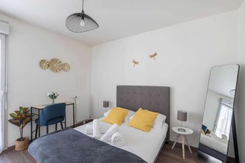 une chambre avec un lit, un bureau et un miroir dans l'établissement Cosy Prusse - Metro 7, La Villette, Paris, quiet, à Pantin