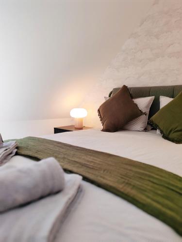 a bed with pillows and a table with a lamp at Ker Yuna & Spa in Dinan