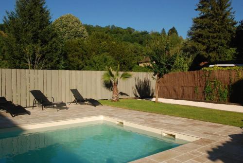 une piscine avec deux chaises et une clôture dans l'établissement Le CLOS MARATUEL, à Sarlat-la-Canéda