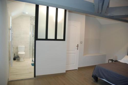 a bedroom with a door leading to a bathroom at Le CLOS MARATUEL in Sarlat-la-Canéda