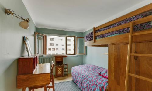 une chambre avec un lit superposé et un bureau dans l'établissement Barbes 2 - CI - Luminous apt for 4 p with balcony - Paris 75018, à Paris