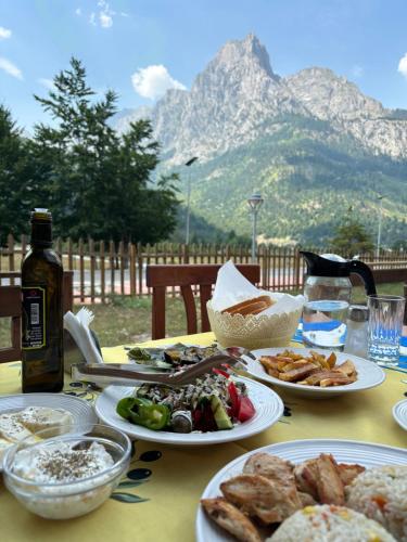 a table with plates of food on it with a mountain at MIK Hotel Valbona in Valbonë