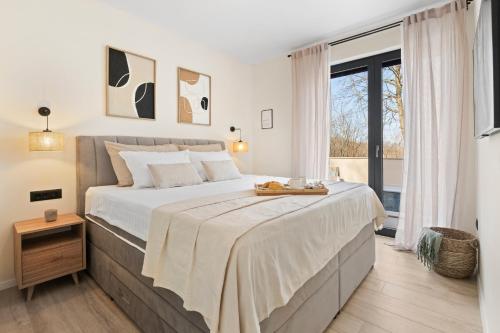a bedroom with a large bed and a large window at Charming Villa Harmonia with Heated pool and Indoor Jacuzzi surrounded by nature in Pićan