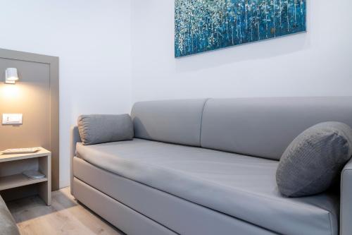 a couch in a room with a painting on the wall at Heart City Rooms in Catania