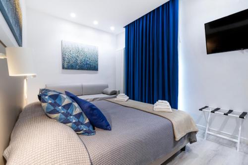 a bedroom with a bed with a blue curtain at Heart City Rooms in Catania