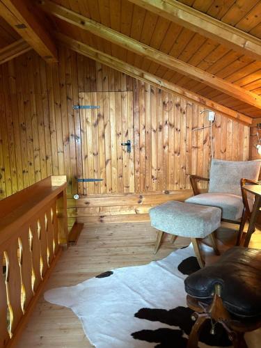 a room with a wooden wall with two chairs and a table at Kircher Hütte in Diex