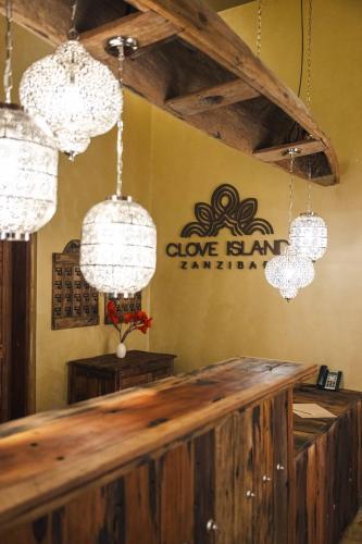 a bar in a restaurant with chandeliers at Clove Island Essence & Spa Boutique in Matemwe