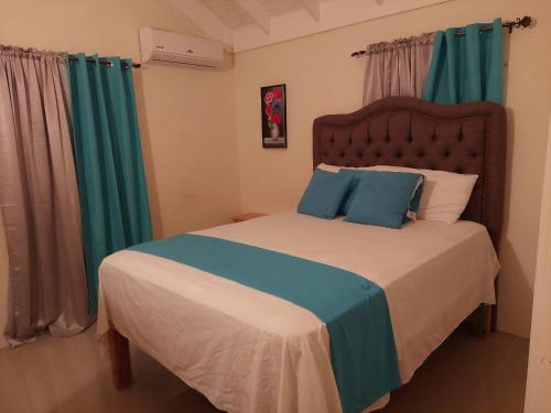 a bedroom with a bed with blue and white pillows at Royal Palm Luxury Villas in Ocho Rios