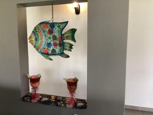 a mirror with a fish hanging on a wall at Feathers and Rest Villa on the banks of the Vaalriver in Parys