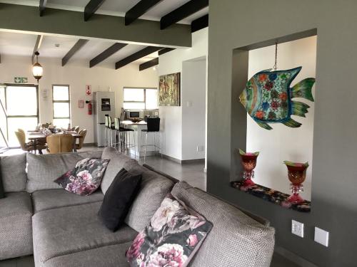 a living room with a couch and a fish painting on the wall at Feathers and Rest Villa on the banks of the Vaalriver in Parys