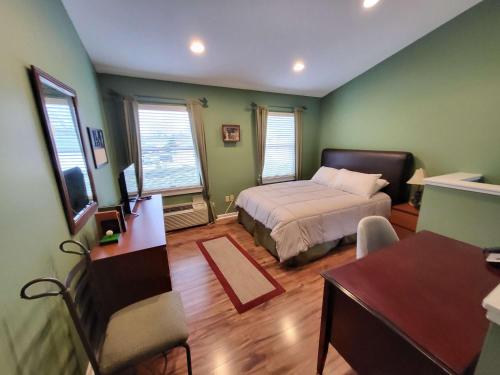 a bedroom with a bed and a desk in it at Suites On Chocolate - The Club in Hershey