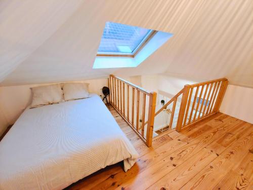 une chambre avec un lit et une lucarne dans l'établissement Maison familiale avec terrasse pour 7 personnes, à Lambersart