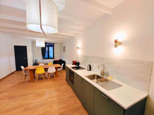 une cuisine avec un évier et une table avec des chaises dans l'établissement Maison familiale avec terrasse pour 7 personnes, à Lambersart