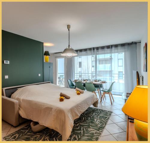 une chambre avec un lit et une salle à manger dans l'établissement Le Manoir I T3 I Ferney-Voltaire, à Ferney-Voltaire